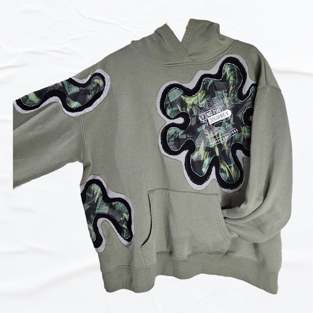 Olive hoodie with abstract  patches on a grey background, upcycled by Vivifica