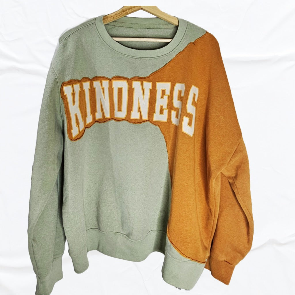 Lime and Tangerine reworked sweatshirt. The word “Kindness” flows across the seam between both tones, One -of-one Upcycled