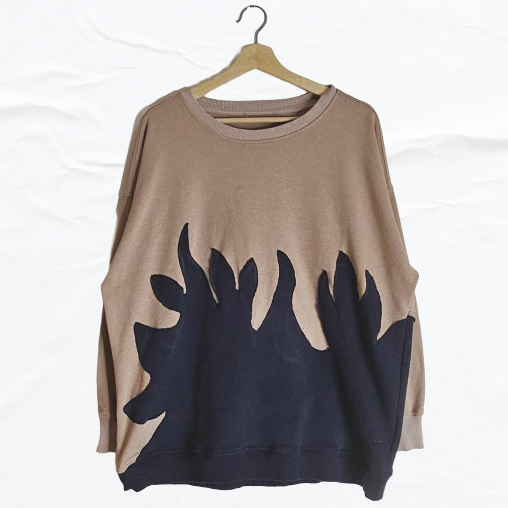 Upcycled beige sweater with black flame cutout appliqué and oversized fit